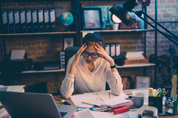 Femme stressée assise à son bureau